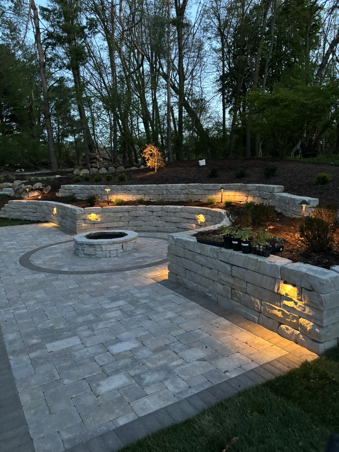 Custom stone block seating wall surrounding patio fire pit