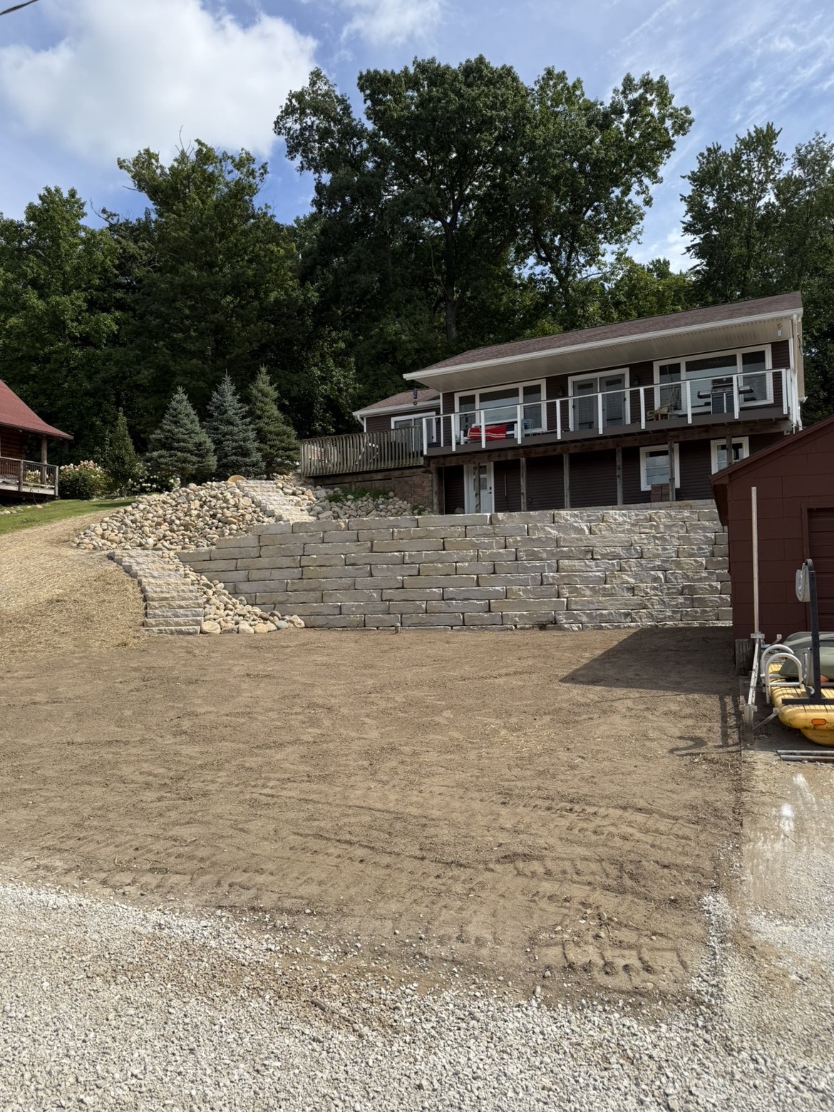Tiered hillside retaining wall and brick paver patio installation in Marshall, MI