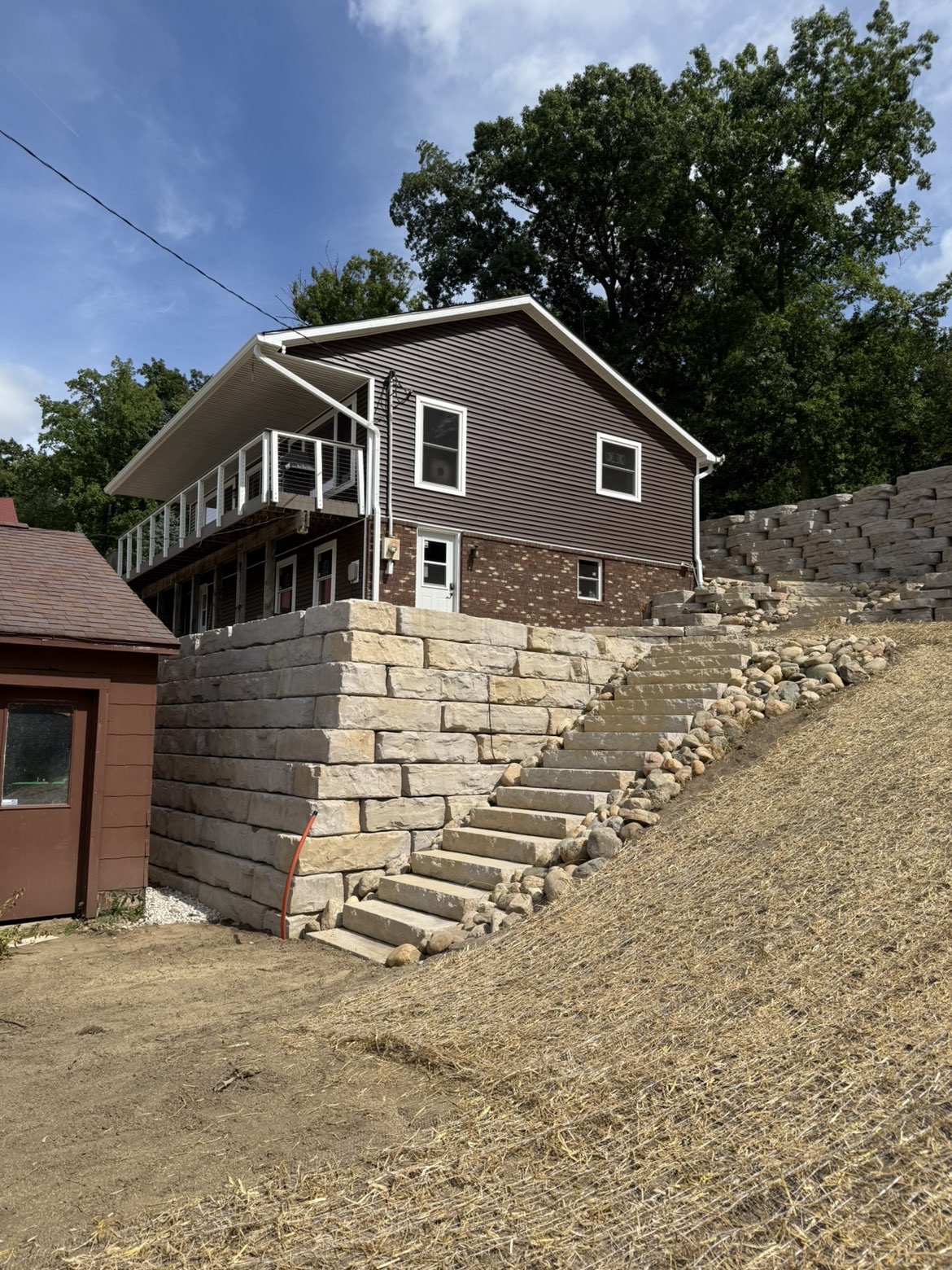 Heavy-duty stone retaining wall base layer installation and leveling