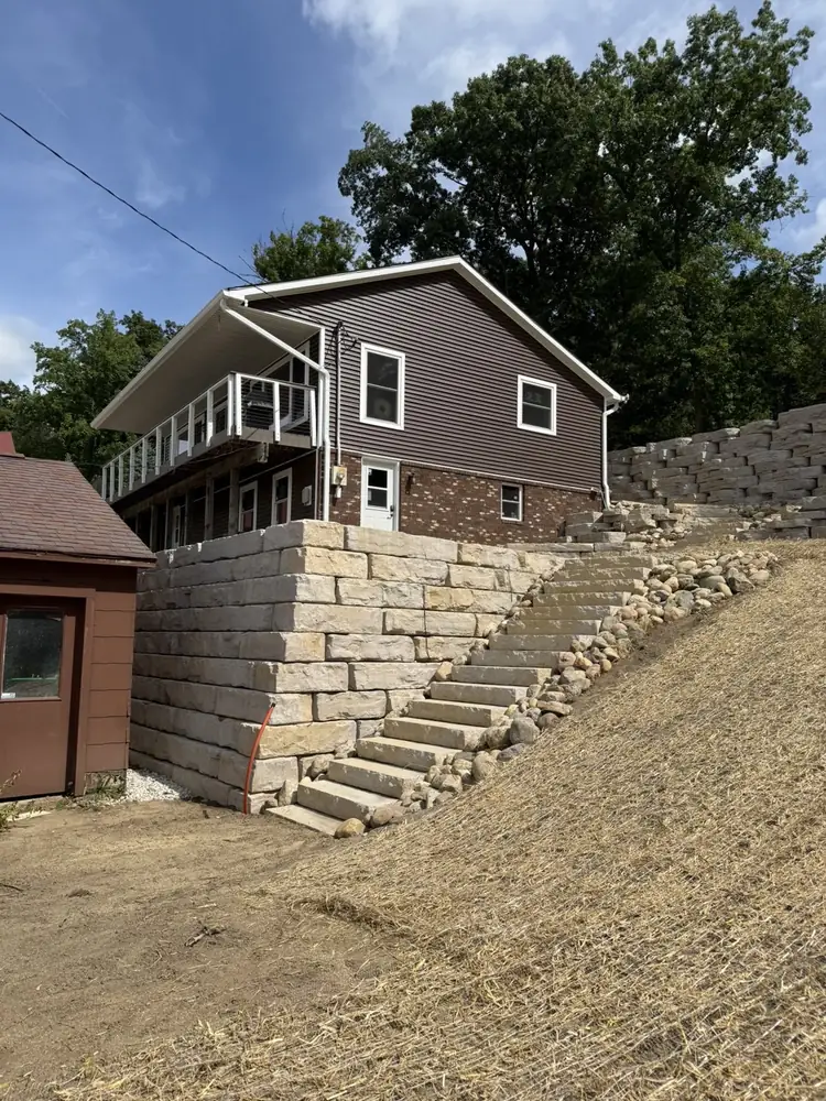 Heavy-duty stone retaining wall base layer installation and leveling