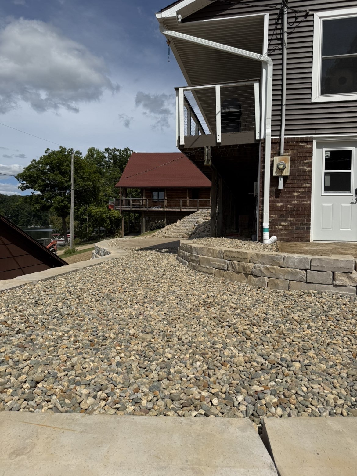Custom paver patio integration adjacent to tiered hillside retaining walls