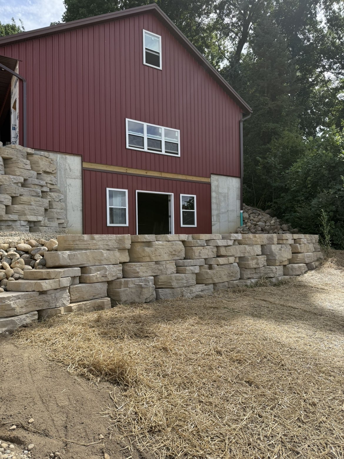 Integrated stone steps connecting upper hillside tier to paver patio